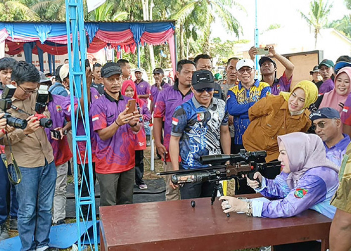 TEMBAKAN : Didampingi sang suami, H Riza Novianto Gustam, Bupati Musi Rawas Hj Ratna Machmud saat mencoba melepaskan tembakan dalam acara Silaturahmi Penghobi Berburu dan Funs Game Perbakin Kabupaten Musi Rawas, di Desa Petrans  Jaya, Kecamatan Muara Keli